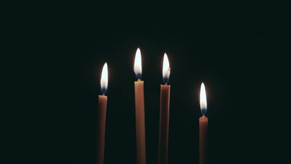 Candles Are Burning, and Spinning on the Table. Black Background alt