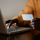 Close up of an african american man using a credit card while typing on a laptop. - PhotoDune Item for Sale