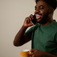 Portrait of an african american man having a phone conversation and drinking coffee - PhotoDune Item for Sale