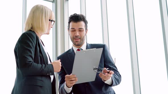 Two Business People Talk Project Strategy at Office alt