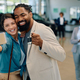 Happy multiracial couple taking selfie after buying a new car in showroom. - PhotoDune Item for Sale