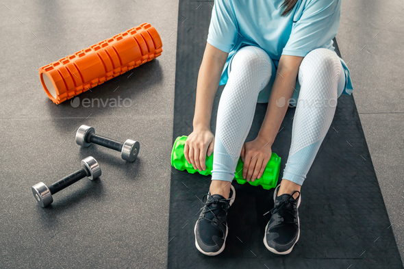 Sport woman using foam roller for muscle and fascia stretching