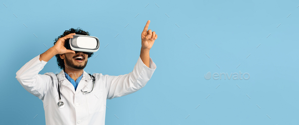 Indian doctor using wireless VR goggles, blue background, web-banner