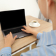 A woman with a cup of coffee is working on a laptop - PhotoDune Item for Sale