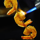 Shrimps strung on a skewer and fried with a burner on a black background - PhotoDune Item for Sale
