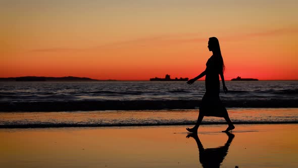Asian woman enjoys a walk on the beach at sunset, Slow Motion alt