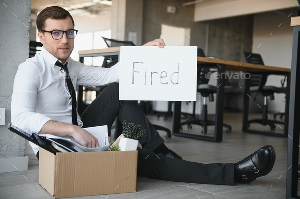fired employee holding fired sign in hand