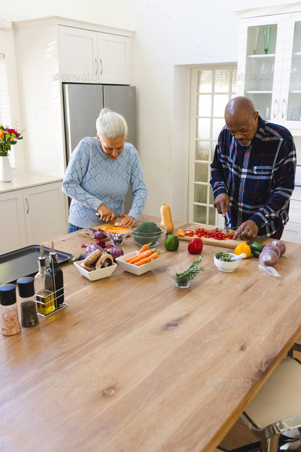 Diverse senior couple chopping vegetables in kitchen Stock Photo by ...