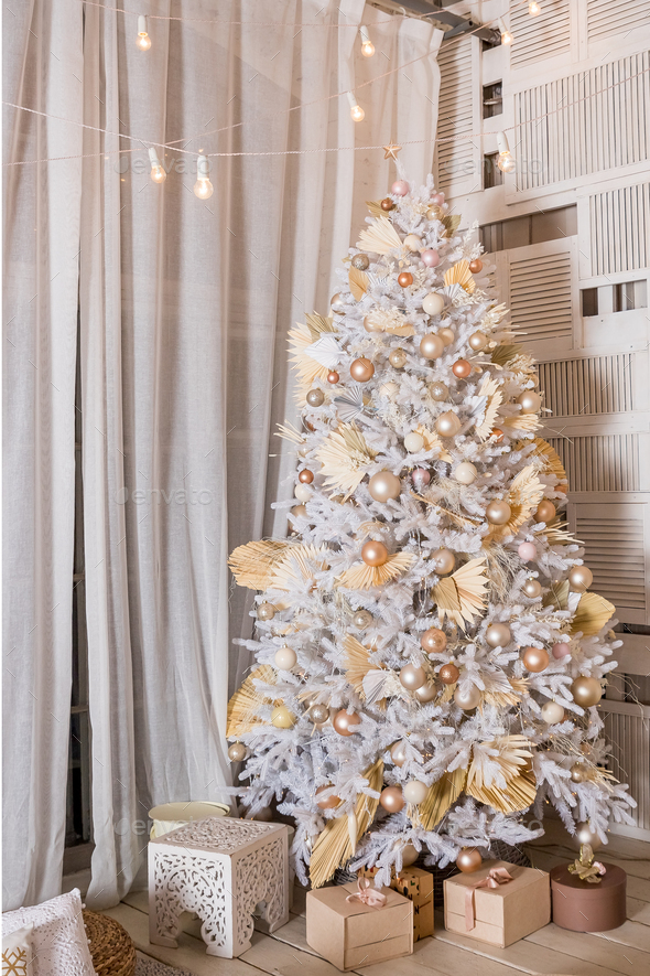 snow-covered Christmas tree with white, golden, bronze decorations and