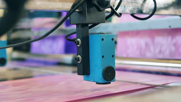 Coloured Wrapping Paper Moving Under a Factory Mechanism alt