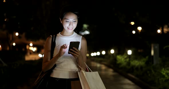 Woman use of smart phone in city at night alt