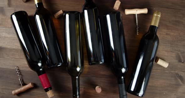 Wine Bottles with Corks and Corkscrews Rotate Slowly. On a Wooden Background. alt