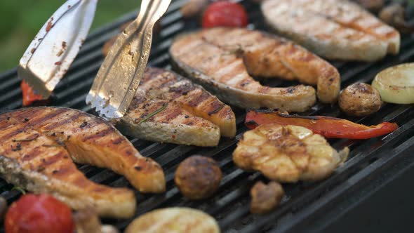 Man Removes Prepared Salmon Steaks From the Grill