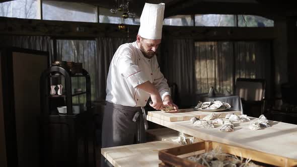 Chef in a Luxury Fish Restaurant Opens Oysters on the Table and Puts Them on a Plate with Ice