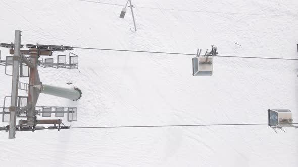 Flying over rope-way with gondolas at mountain resort Crystal Park in Bakuriani. Snowy winter day. alt