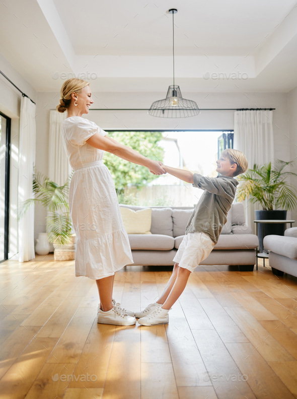 Mom, dance and holding hands with child in home, living room or lounge with trust, support or balan