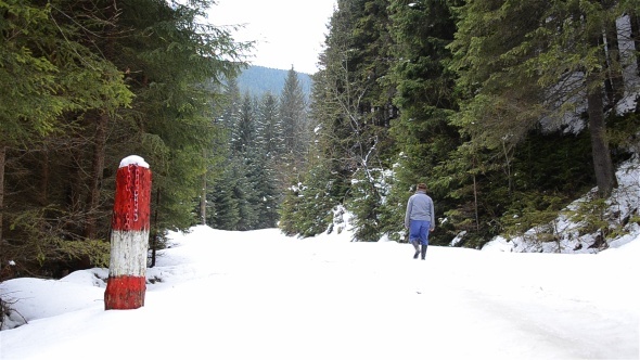 Man Walking In Snowy Winter Forest