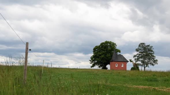 time lapse of a meadow in friesenhagen germany with the  st anna chapel and two trees in the distanc alt