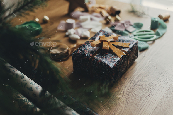 Wrapping christmas gifts. Stylish festive wrapping paper, ribbons, scissors,  bows, vintage ornaments Stock Photo by Sonyachny