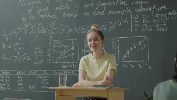 Portrait of Cheerful College Girl in Classroom alt