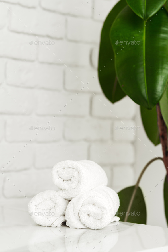 Stacked clean fluffy towels in a bathroom Stock Photo by FabrikaPhoto