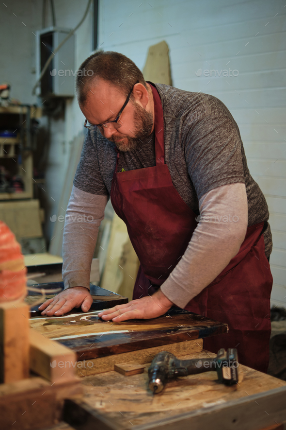 Hands guide wood through a cutter. Precision meets tradition in