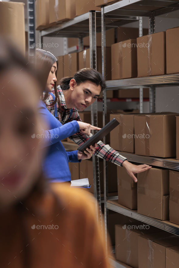 Warehouse employees inspecting parcels on rack and doing inventory