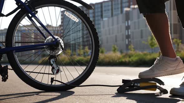 Man Inflating Bike Tire Outdoors alt
