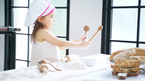 Little Girl Preparing Dough and Bake Cookies in the Kitchen While Learning in the Class at School alt