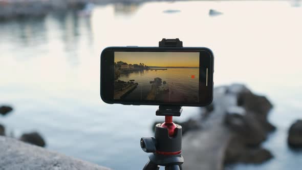 Close Up Smartphone Recording Time Lapse of Sunrise or Sunset at the Sea Coast alt
