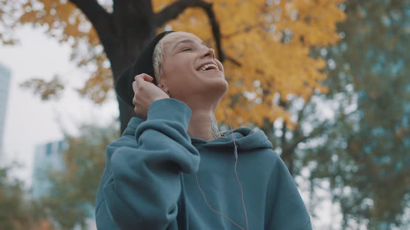 Crazy Confident Young Woman with Winter Black Hat Listening To the Music From Smartphone Using alt