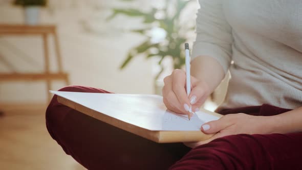 Woman Artist Sketching on White Paper Sitting on The Floor