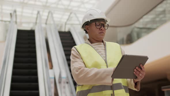 Construction Worker Using Tablet in Mall alt