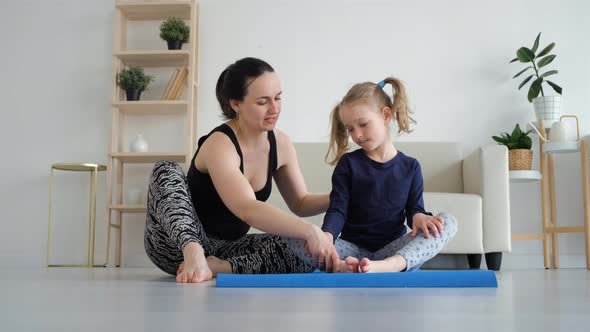 Woman Training on a Mat with Little Daughter alt