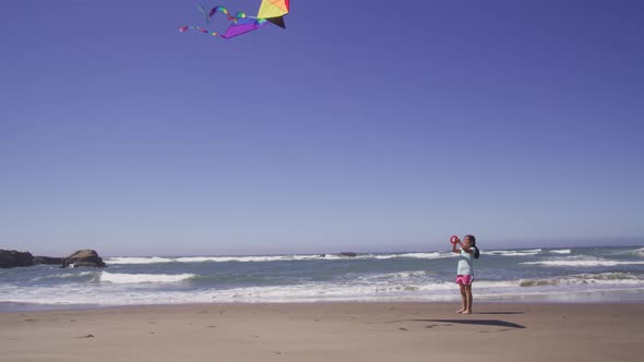 Young girl flying kite at beach