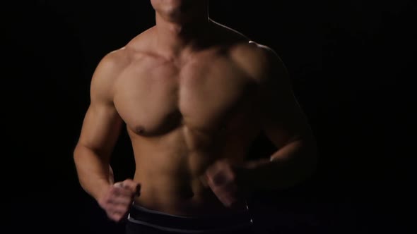 Man Athlete Running at Fast Pace on Black Background. Studio alt