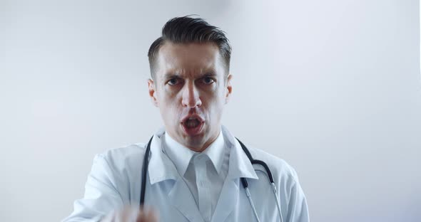 Closeup of Angry Doctor Scolding and Shouting at Employees Threatening with a Finger and Shouting alt