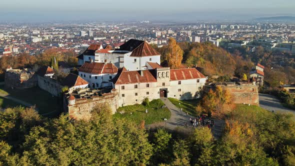 Aerial drone view of The Citadel in Brasov at sunrise, Romania. Medieval fortress on the top of a hi alt