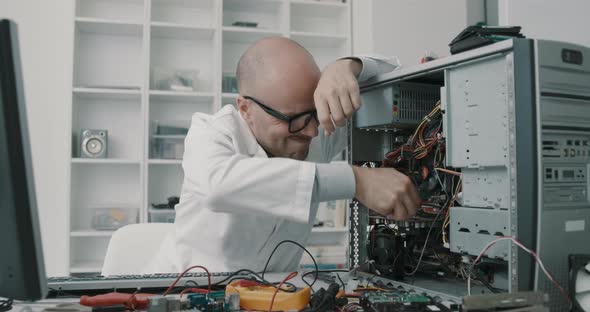 Technician damaging a computer with a screwdriver