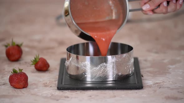 Girl Pastry Chef Pours Strawberry Puree Into a Pastry Ring
