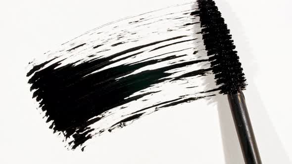 Macro Shot and Slow Motion of a Black Mascara Isolated on White Background alt