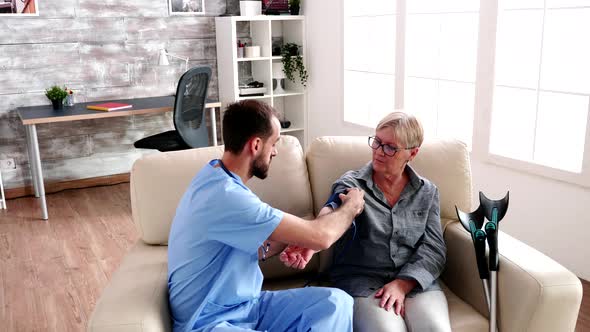 Doctor in Retirement Home Measuring the Blood Pressure alt