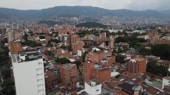 Fly down toward building rooftops in a large city, Medellin, Colombia ...