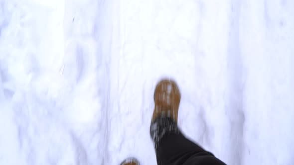 A Man In Brown Boots Walks Through The Snowdrifts In Winter