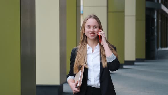 Confident Young Woman in Suite and White Shirt Talking By Phone