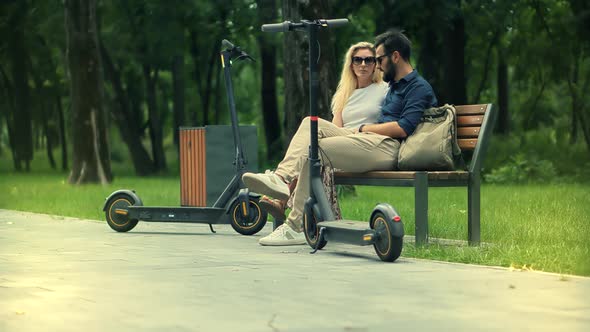 Renewable Energy Transport. Boyfriend And Girlfriend Enjoying Time Together In Park.E-Scooter Riding alt