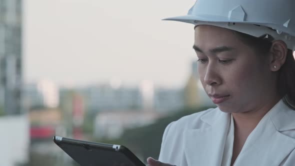Female construction engineer with a tablet computer at a construction site. alt