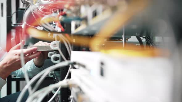 Sliding shot of a technician inserting a board into a fiber optic server alt