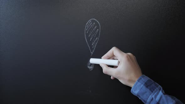 Male hand draws exclamation mark on chalkboard alt