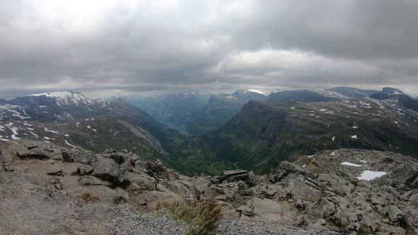 Timelapse movie from Dalsnibba viewpoint towards Geiranger Fjord in Norway with low clouds alt